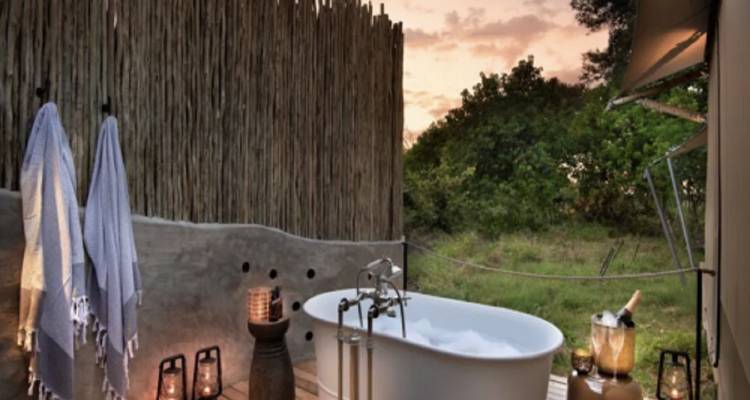 An outdoor bathtub setup with a sunset view.