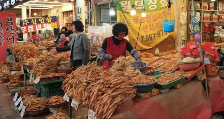 Étal de marché vendant du ginseng avec diverses racines exposées.