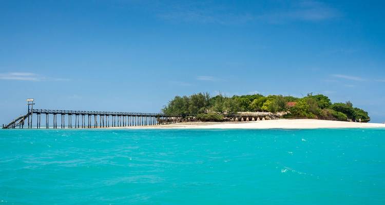 Insel mit einer Holzbrücke, die sich ins blaue Meer erstreckt.