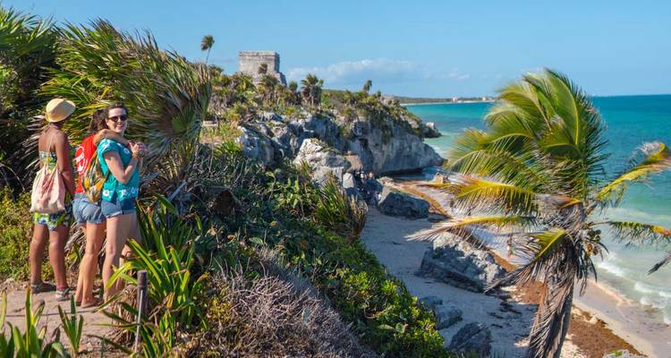 Femmes explorant des ruines côtières avec vue sur l'océan.
