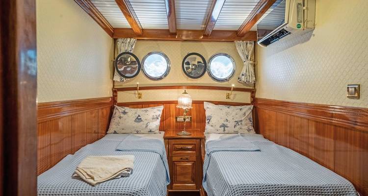 Gezellig hutinterieur met twee eenpersoonsbedden en patrijspoortvensters.