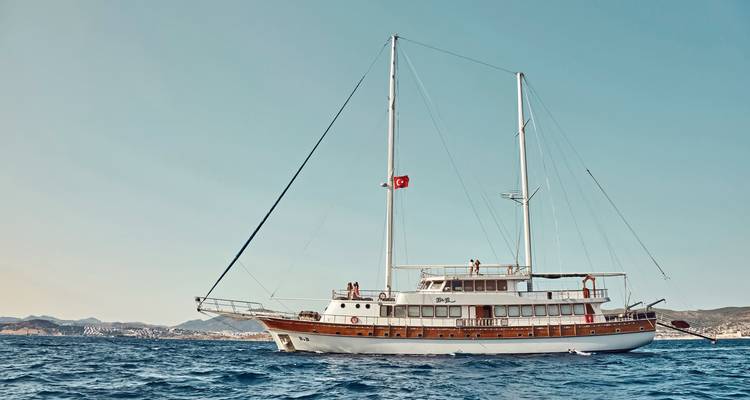 Een grote zeilboot op zee met een Turkse vlag, mensen zichtbaar op het dek.