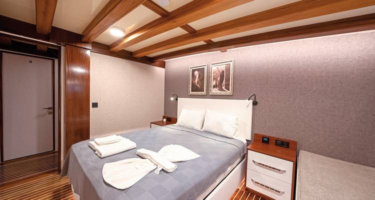 Een gezellige huttenkamer met een bed en netjes gevouwen handdoeken.