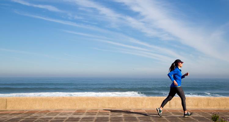 Personne faisant du jogging au bord de la mer par une journée claire.