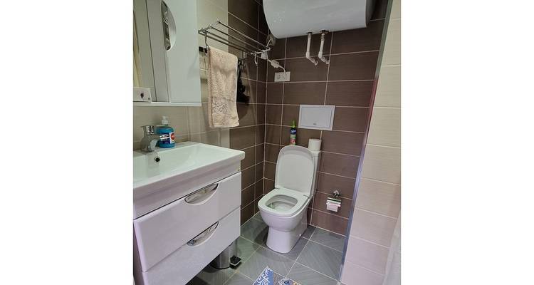 Une salle de bain avec des toilettes, un lavabo et un miroir.