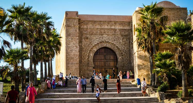 Porte historique proéminente avec des gens rassemblés à l'entrée.