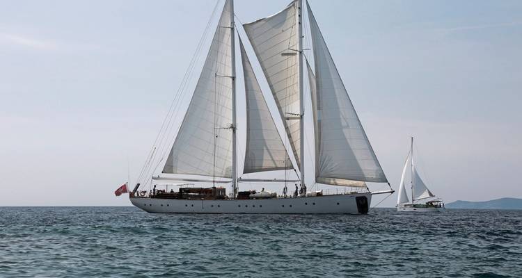 Large sailboat on the ocean with sails unfurled.