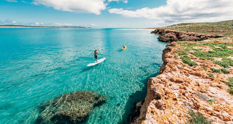 Des personnes pratiquant des activités aquatiques dans un lagon cristallin.
