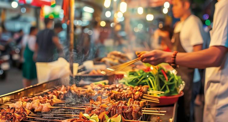 Street food vendor grilling skewers at a night market.