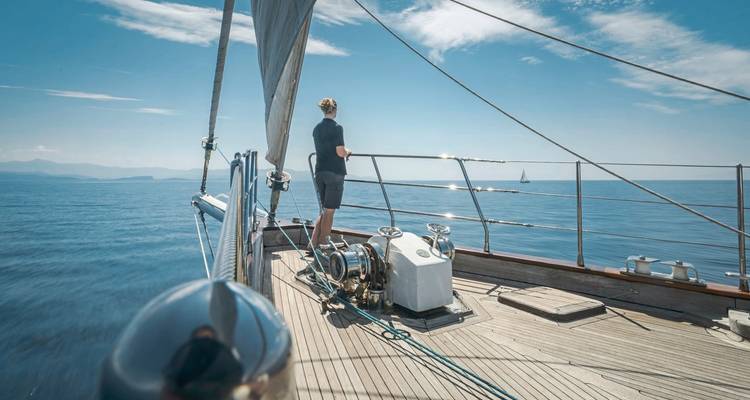 Person on a yacht looking out over the sea.