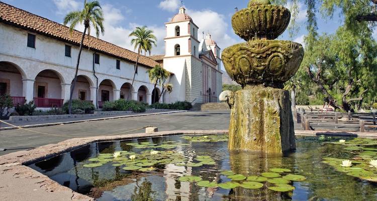 Mission-style building with a fountain in the foreground.