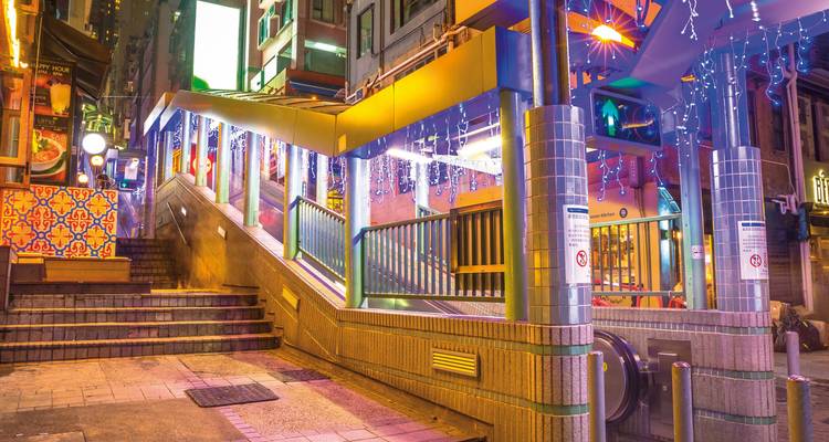 Rue de Hong Kong avec des décorations éclairées et des escaliers mécaniques.