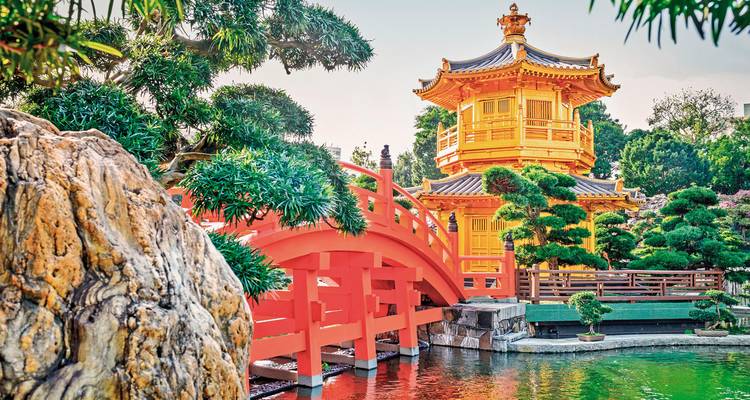 Traditioneller chinesischer Pavillon mit roter Brücke in einer Gartenanlage, Hong Kong.