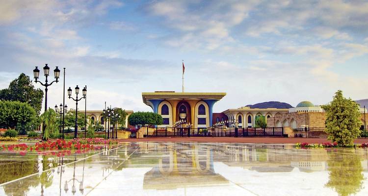 Un gran edificio arquitectónico con un patio húmedo y reflectante.