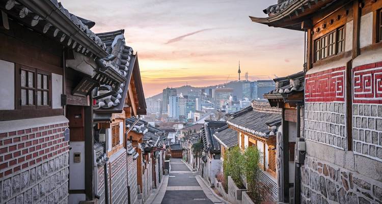 Traditionele Koreaanse huizen langs een smalle straat met stadsgezicht op de achtergrond, Seoul, Zuid-Korea.