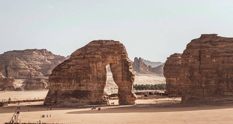 Rock formations in the desert with people around.