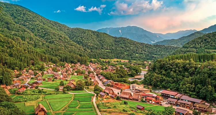 Village traditionnel dans un cadre de vallée luxuriante.