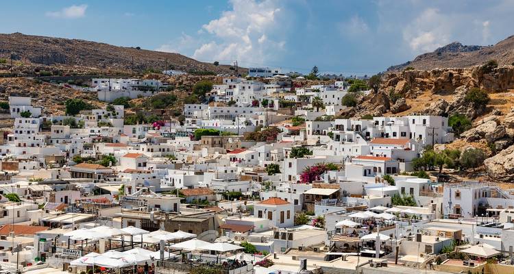 Ville blanchie à la chaux avec des rues étroites et un paysage vallonné.