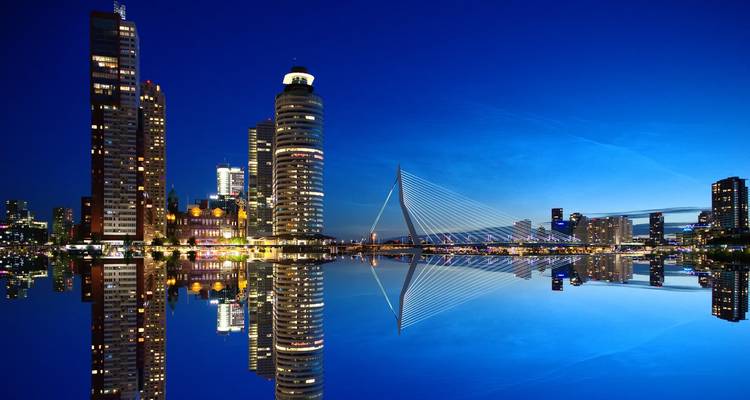 Paysage urbain de nuit avec architecture moderne et un pont.