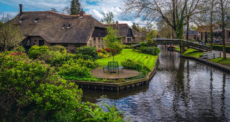 Charmant canal et cottages au toit de chaume dans un cadre verdoyant luxuriant.