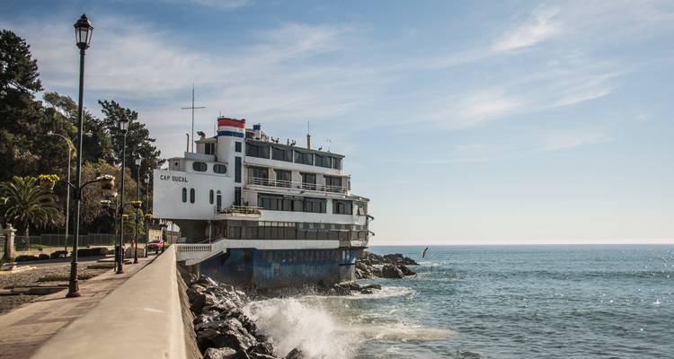 Grand bateau amarré le long d'un mur de pierre sur la côte.