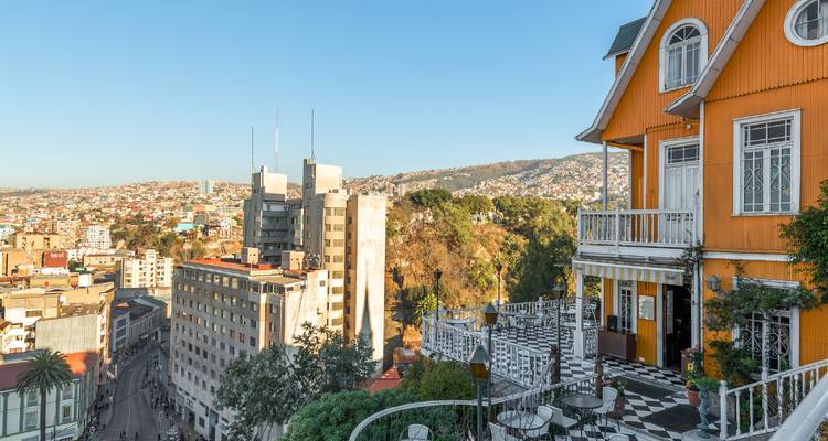 Paysage urbain coloré à flanc de colline avec bâtiments historiques et décor urbain.