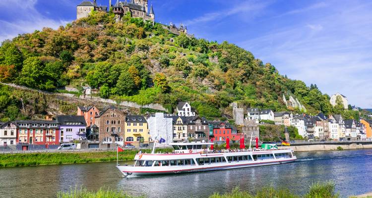 Riviercruiseschip dat voorbijvaart langs historische gebouwen en heuvels in Cochem.