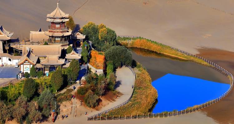 Crescent Lake surrounded by desert and a historic pagoda-style building.