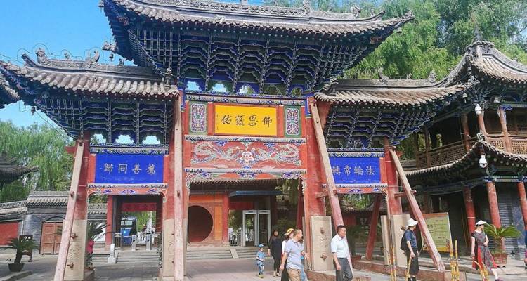 Decorative traditional Chinese gate with tourists around.