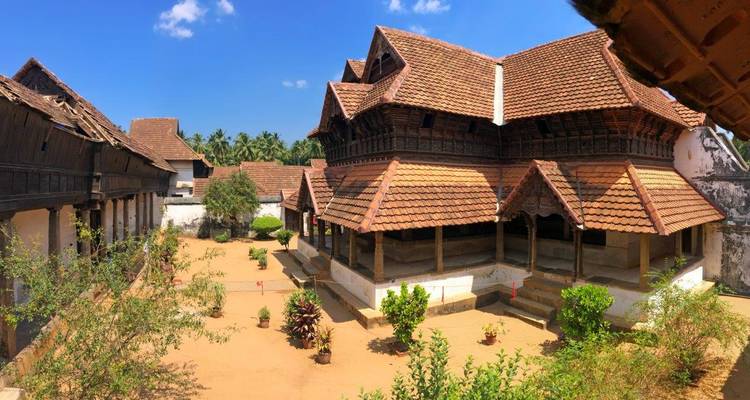 A traditional Kerala style house with tiled roofs and an open courtyard.