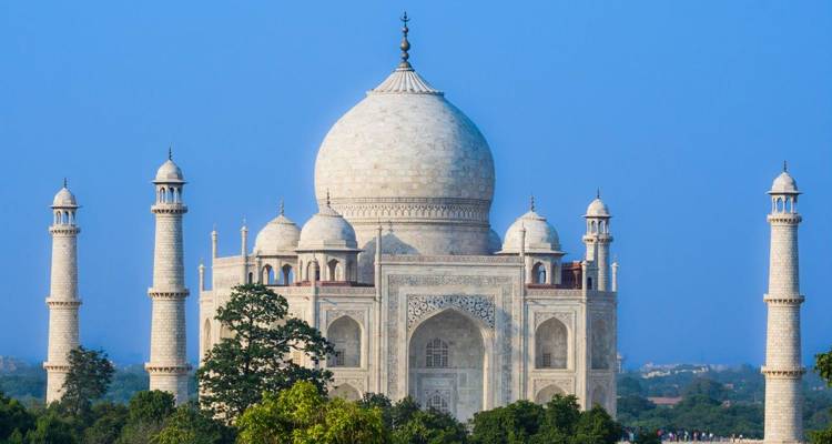 Clear view of Taj Mahal with its iconic white marble domes against a blue sky.