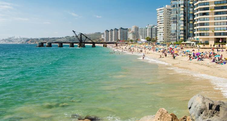 Playa en Viña del Mar con gente relajándose y nadando.