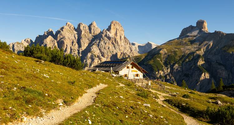 Eine gemütliche Berghütte umgeben von atemberaubenden Gipfeln.