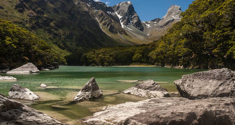Paysage alpin avec un lac et des sommets rocheux.