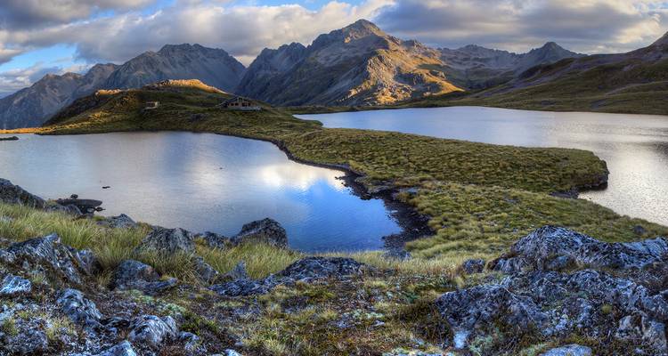 Lac alpin immaculé avec montagnes environnantes et prairies.