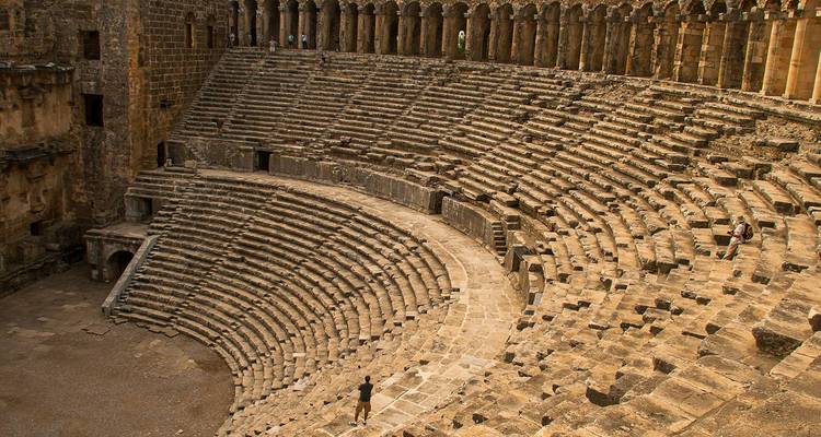 Impressive ancient Roman amphitheatre of Aspendos with semicircular stone seating.