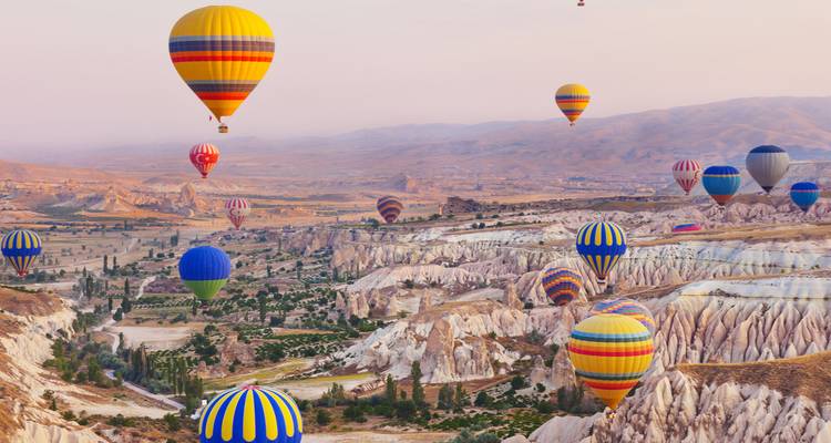 Hot air balloons over Cappadocia's rock formations.
