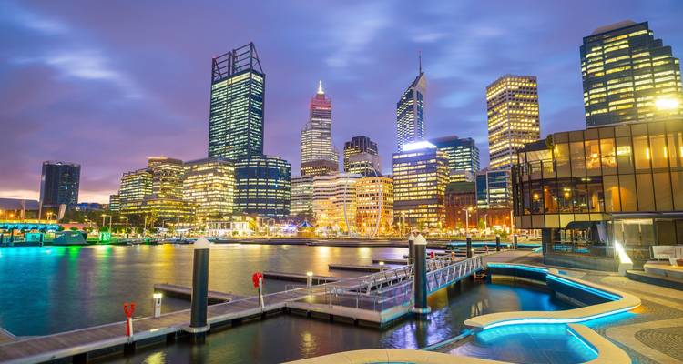 Port de ville avec bâtiments illuminés au crépuscule.