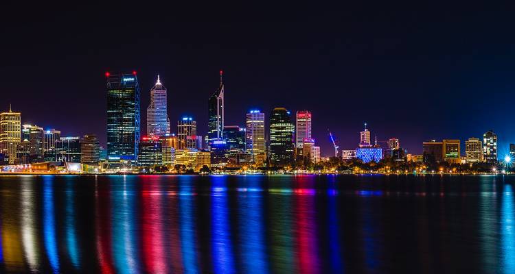 Vue nocturne de l'horizon urbain avec reflets sur la rivière.