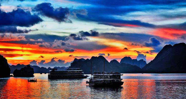 Beautiful sunset over the sea with boats and islands silhouetted in the background.