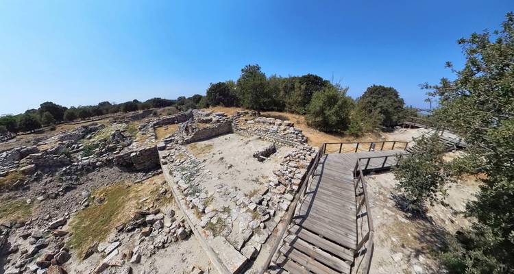 Oude ruïnes en bomen op een zonnige dag.