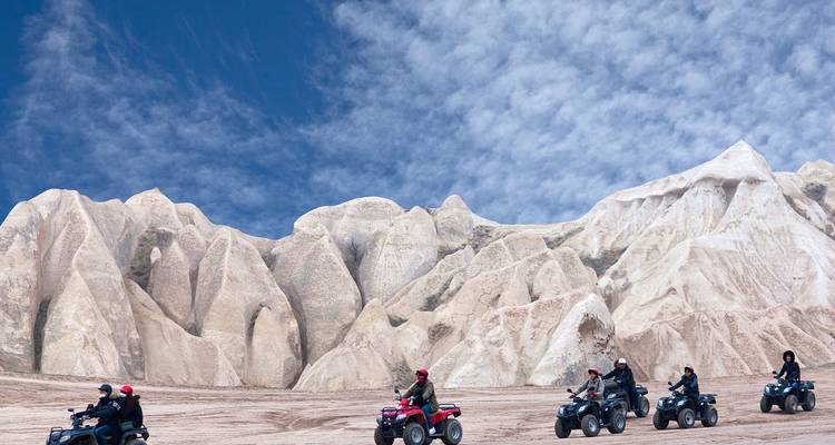 Conductores de cuatrimotos explorando terreno rocoso.