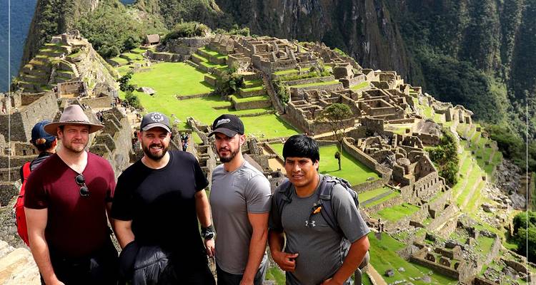 Group of people standing in front of ancient ruins.