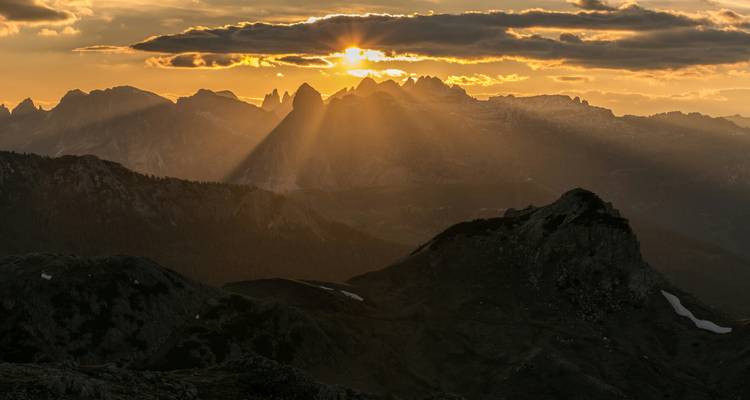 Chaîne de montagnes avec des rayons de soleil perçant à travers les nuages