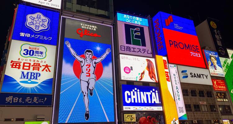 Heldere neon reclameborden in een levendige stedelijke omgeving 's nachts.