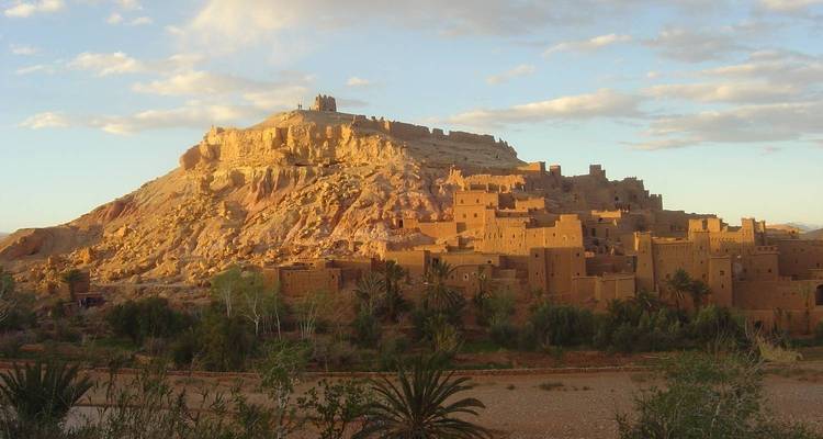 Une vue de l'ancien Ksar d'Aït-Ben-Haddou avec une lueur chaude de coucher de soleil.