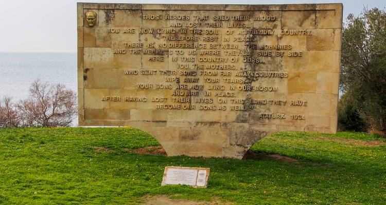 Muro conmemorativo with inscripciones con vista al mar.