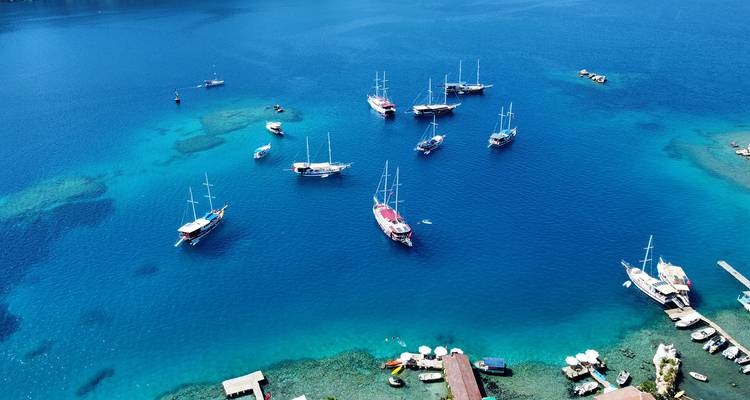 Boote verstreut in einer ruhigen blauen Bucht nahe der Küstenlinie.