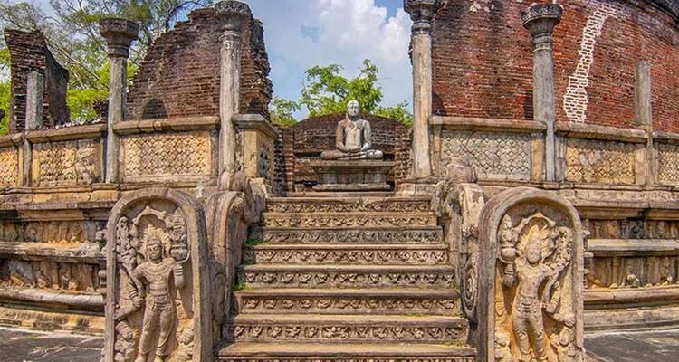 Anciennes ruines de pierre avec des sculptures complexes et une statue.