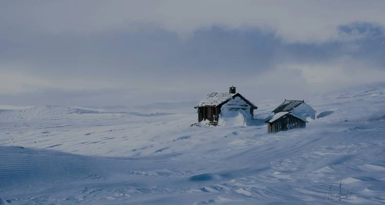 Cabañas aisladas en un desierto cubierto de nieve.